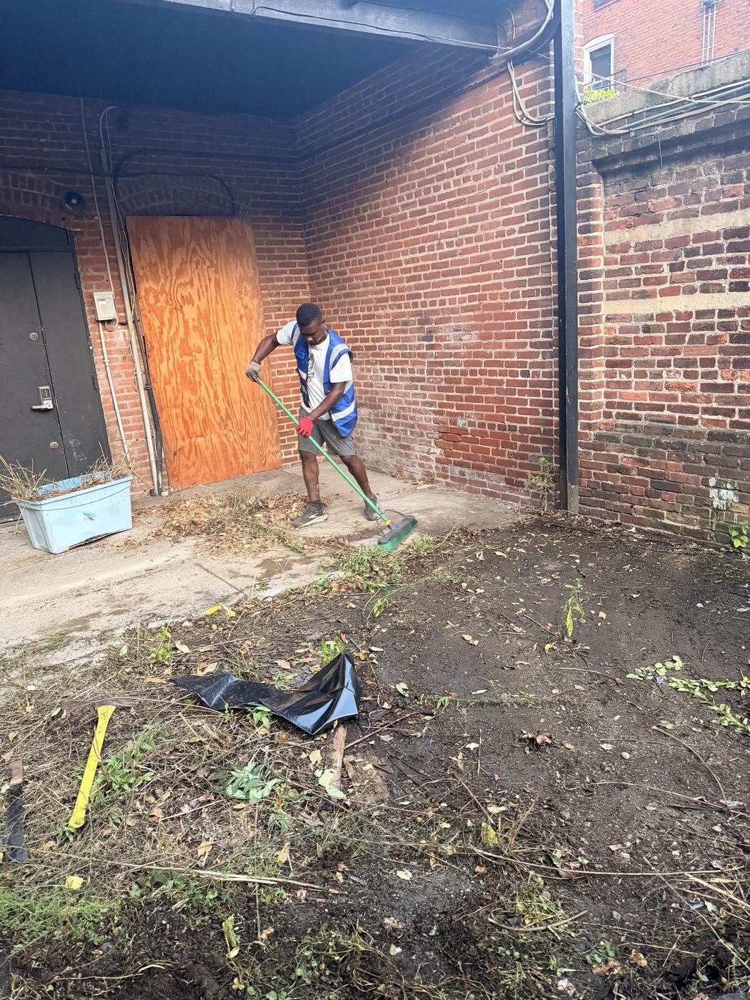 Crew sweeping a brick alley after the haul