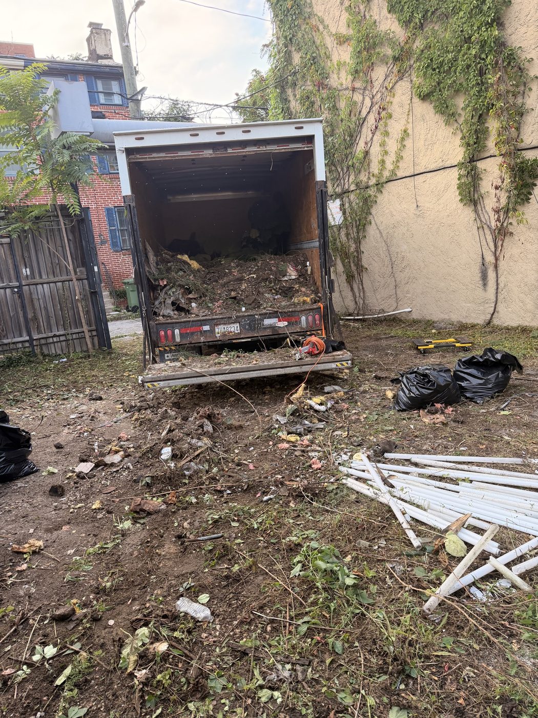 Box truck filled with yard debris and dirt
