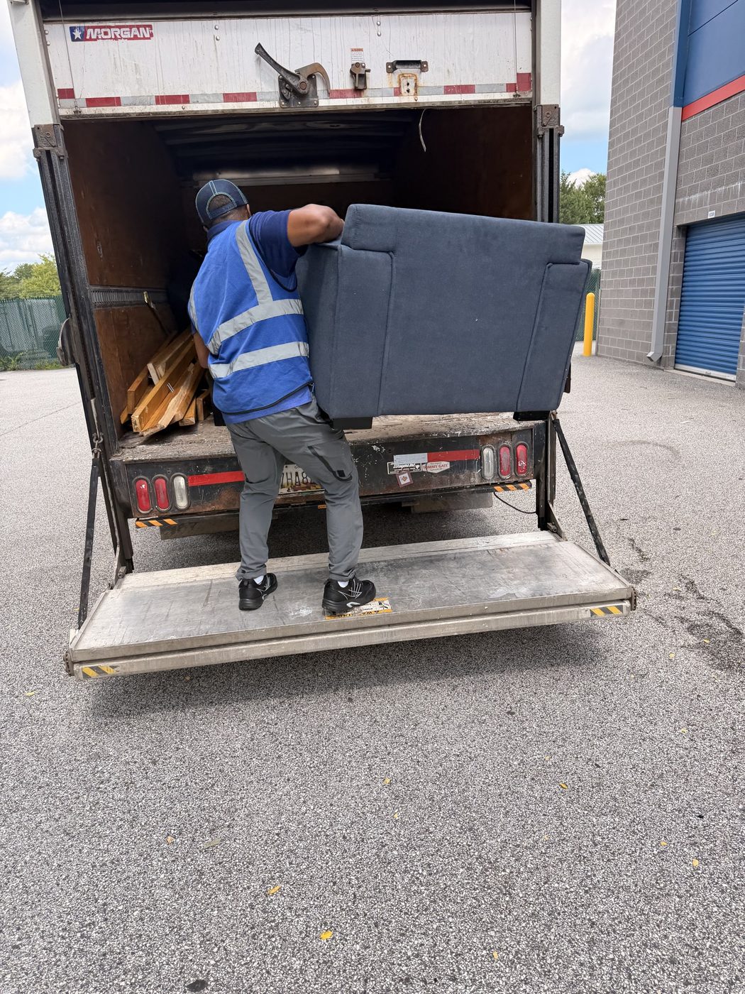 Crew member loading a sofa into the box truck